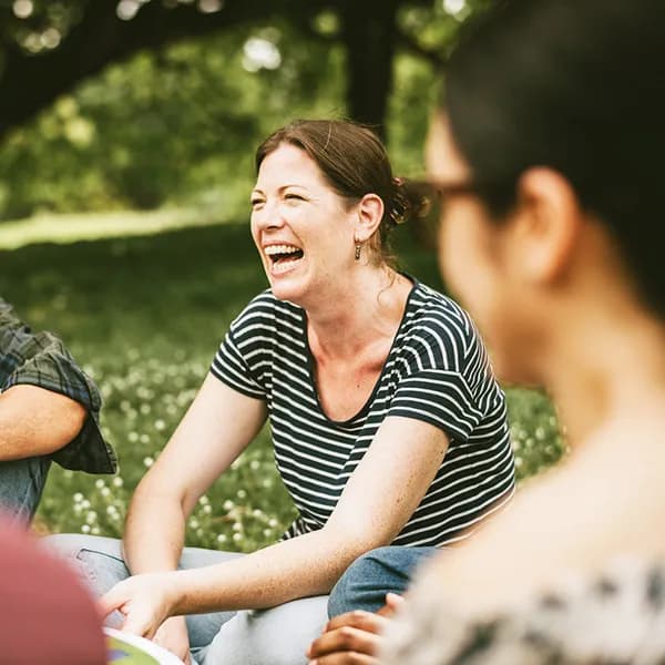 Personen sitzen m Gras vor der Dr. Römer Klinik